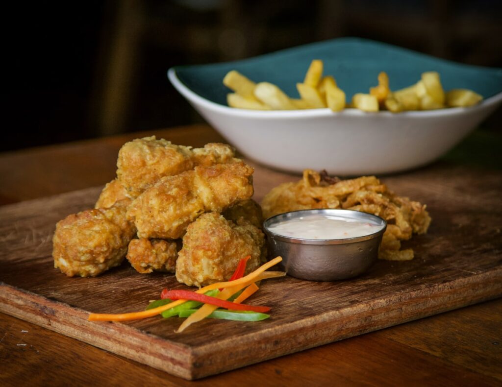 Crispy air fryer chicken wings tossed in sauce on a wooden board