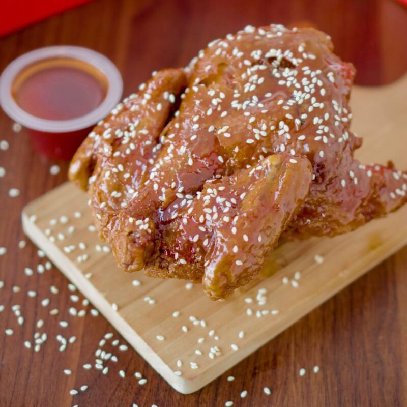 Sticky honey garlic chicken thighs glazed and garnished with sesame seeds and green onion