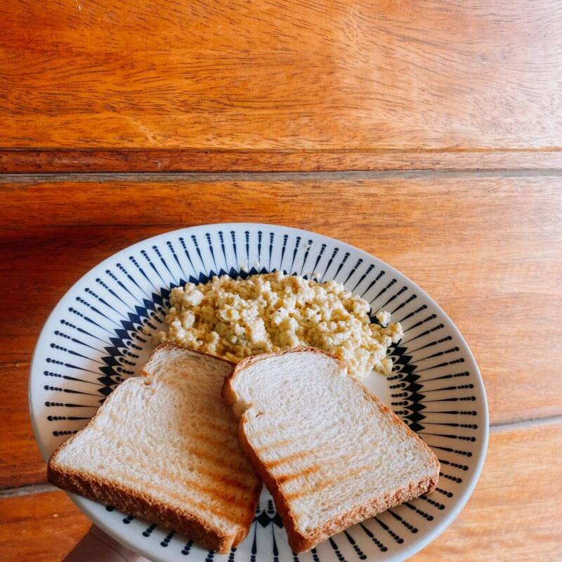 Fluffy scrambled eggs served with bread on a plate