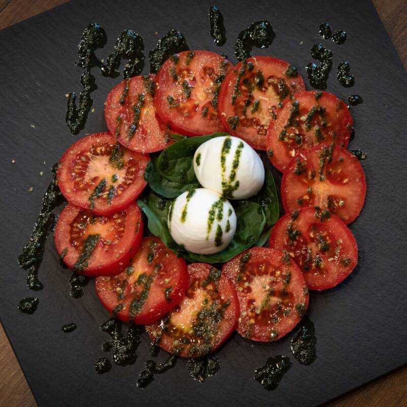Fresh mozzarella, tomatoes, and basil used to top a baked ziti recipe