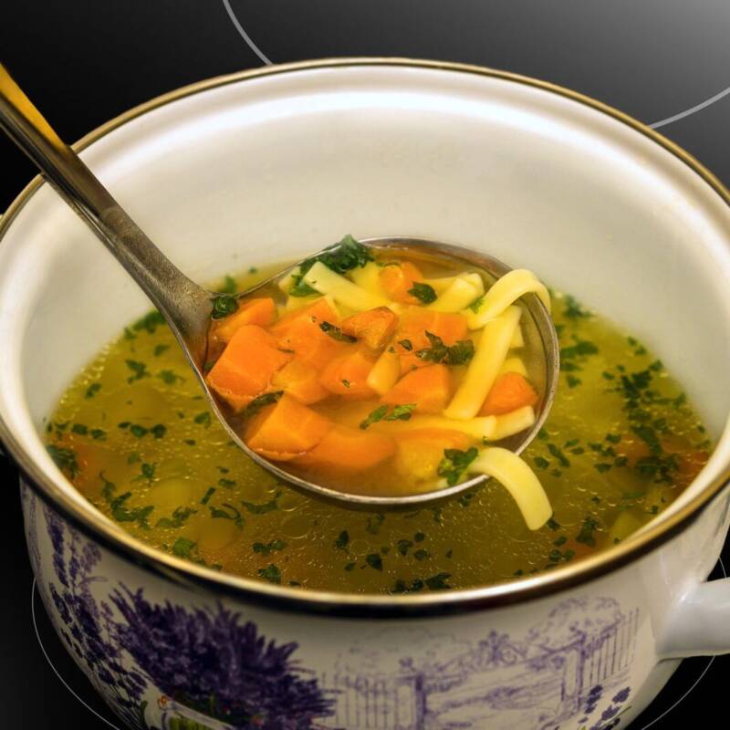 Hearty homemade chicken noodle soup in a ceramic pot