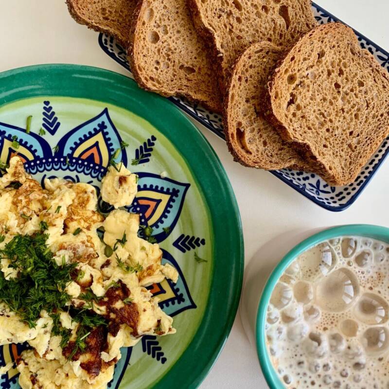 Healthy breakfast of fluffy scrambled eggs and brown bread