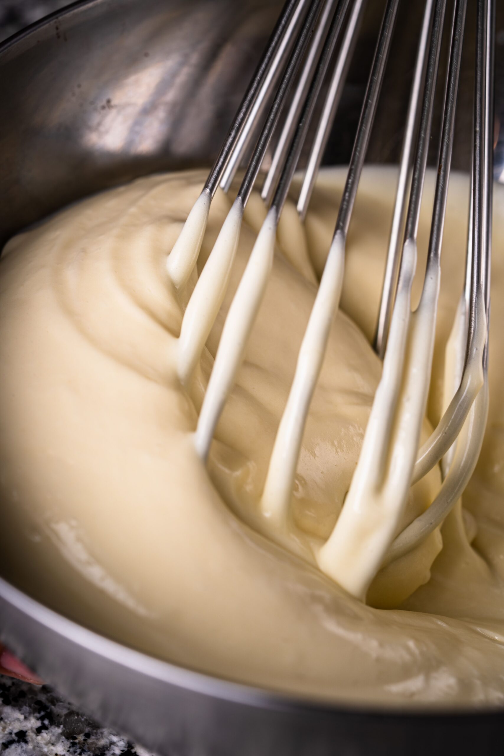 Whisking fluffy buttermilk pancake batter smooth in a mixing bowl