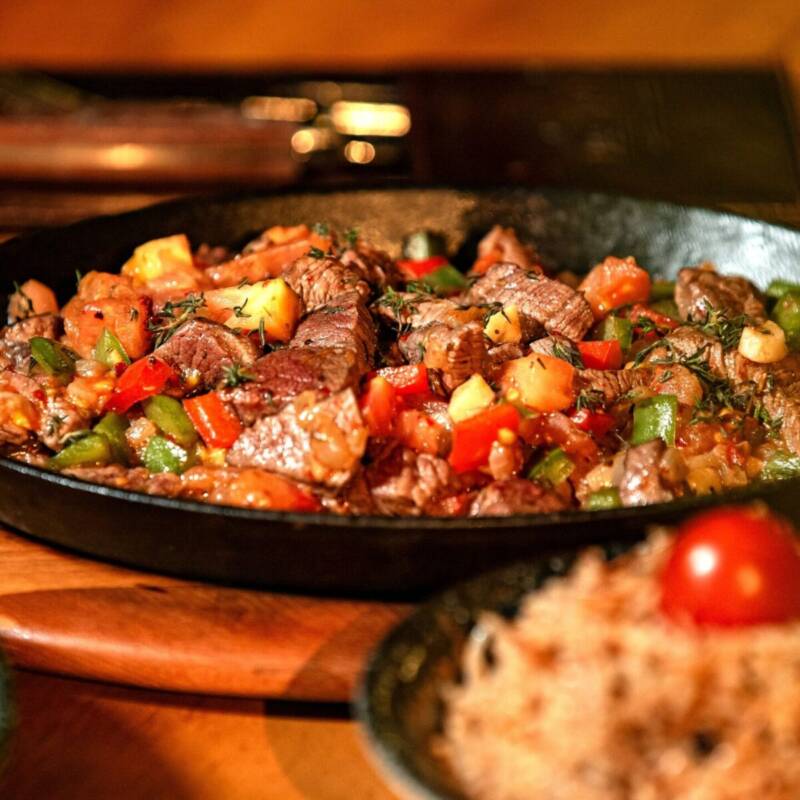 Close-up of savory beef and broccoli stir fry with vegetables in a rustic skillet