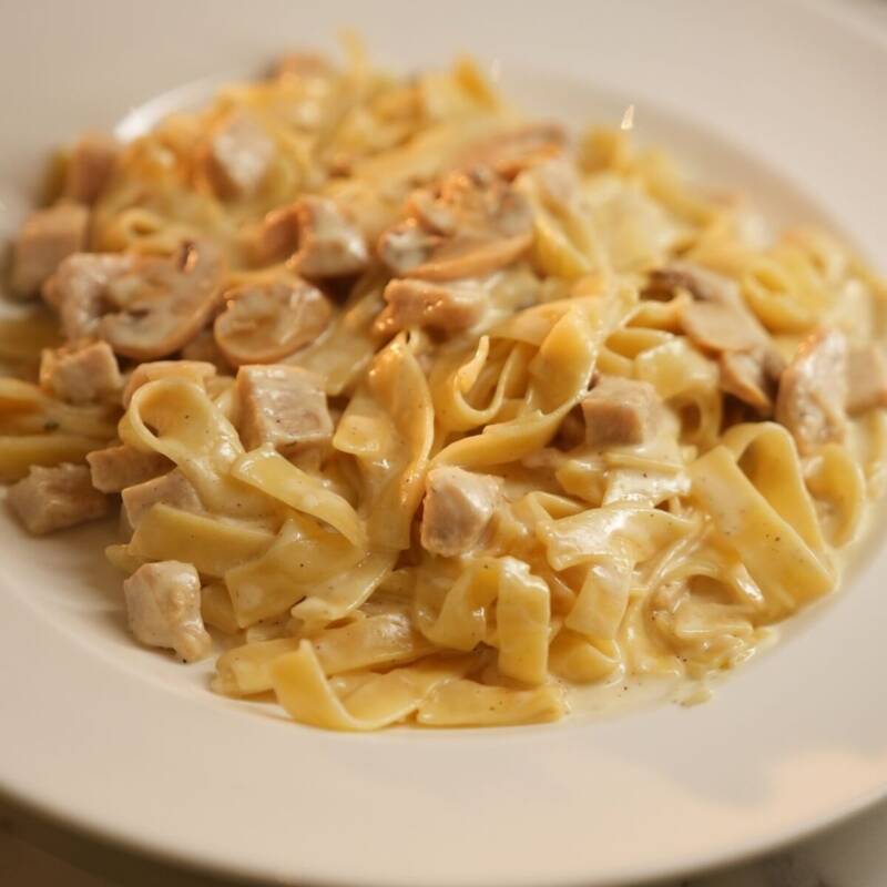 Creamy one pot chicken alfredo pasta on marble table