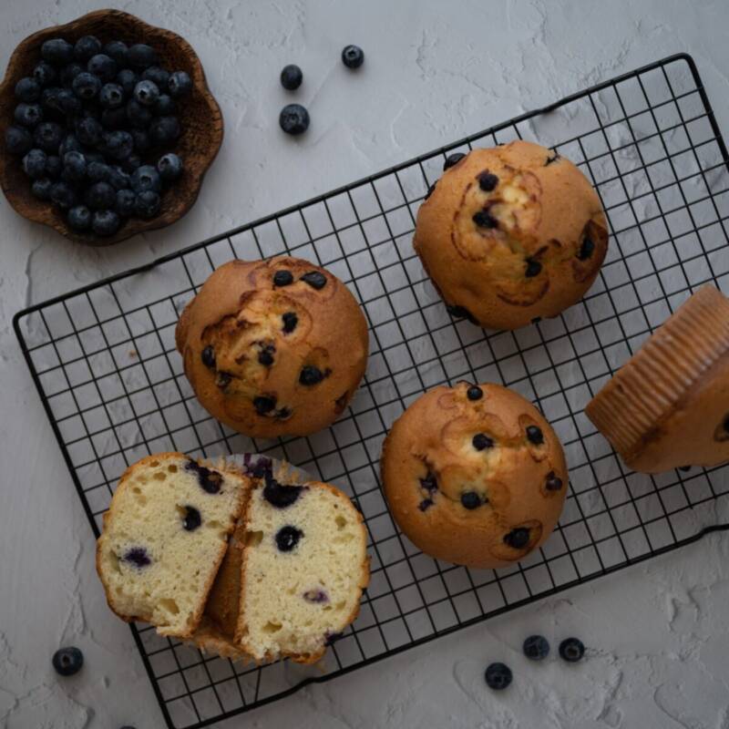 Close up of a blueberry muffin split open showing a moist crumb